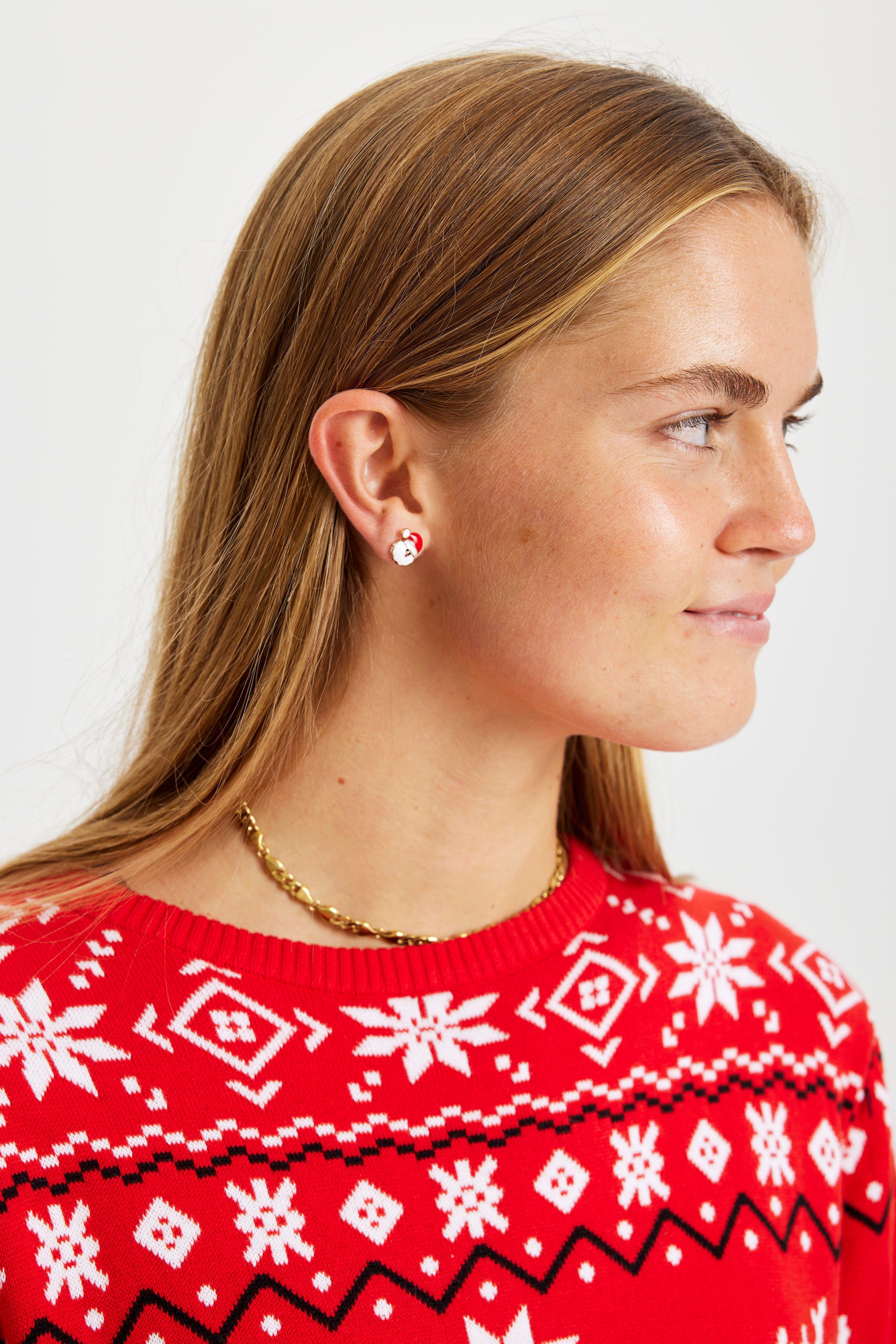 En kvinde juleøreringe, der ligner julemanden.